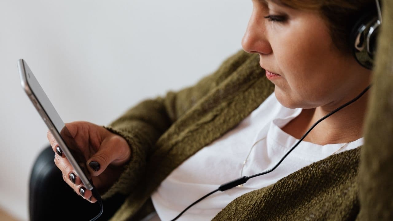 音楽を聞きながらスマホを見ている女性